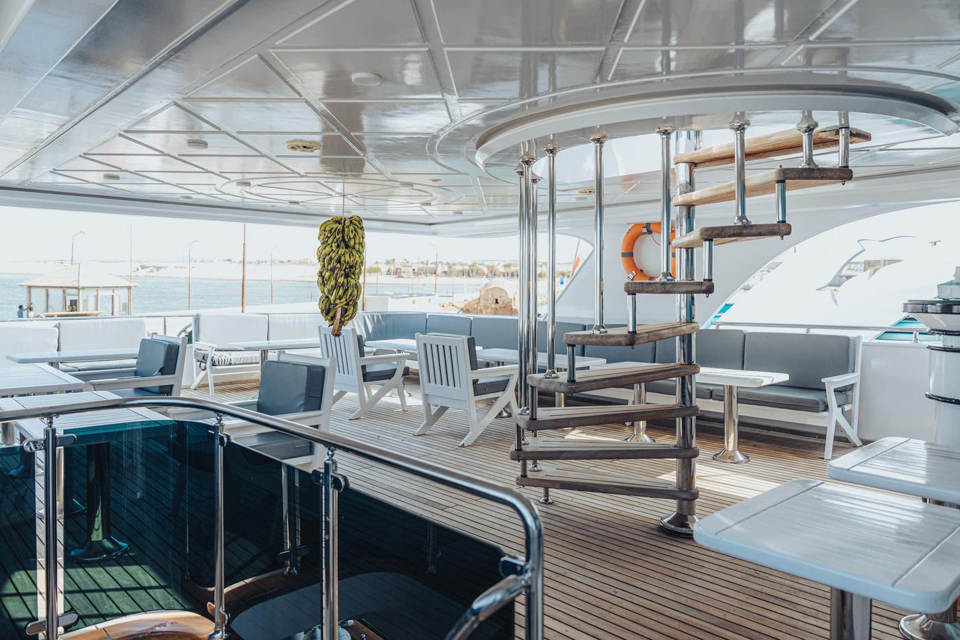 The yacht's shaded upper deck with seating and ocean views