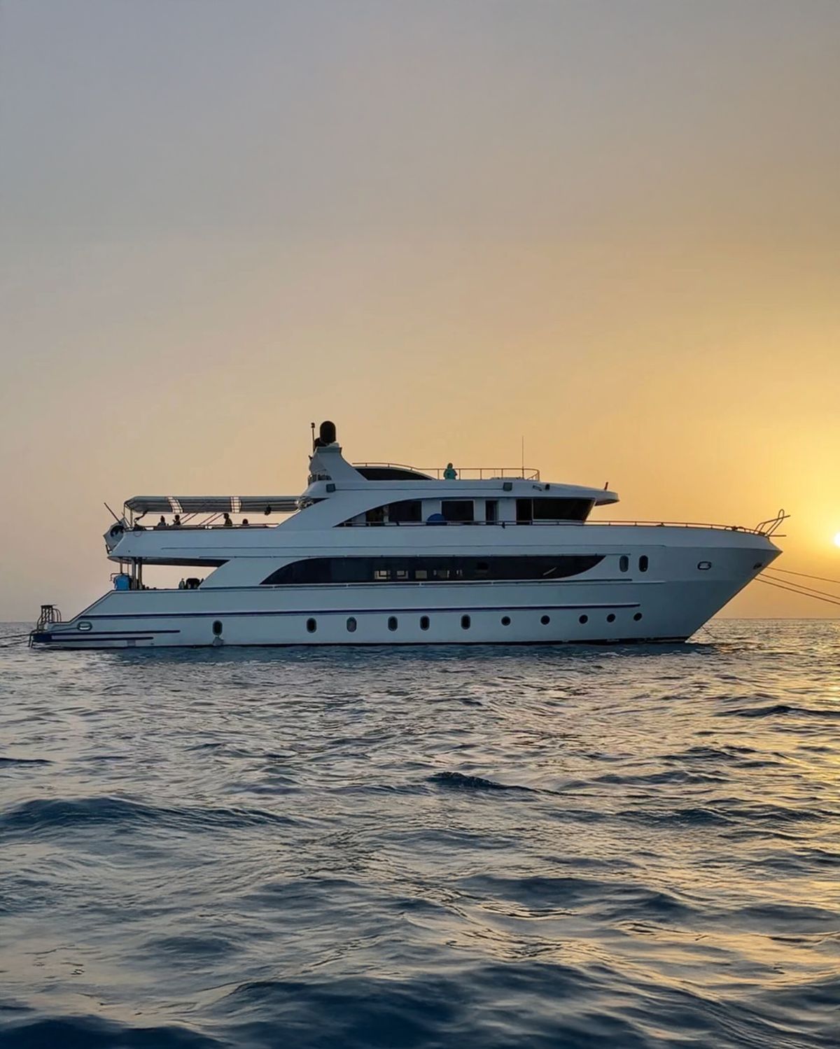 The liveaboard yacht at anchor at sunset